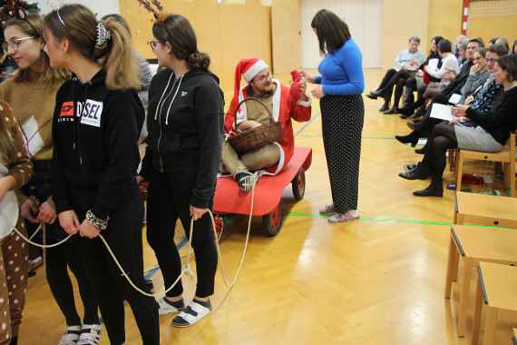 Fremdsprachenassistent  im Santa Claus-Kostüm verteilt Geschenke an die Schulgemeinschaft