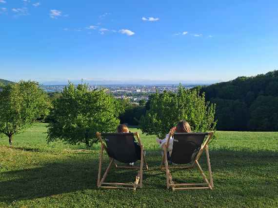 Zwei Schülerinnen blicken vom Liegestuhl aus nach Linz