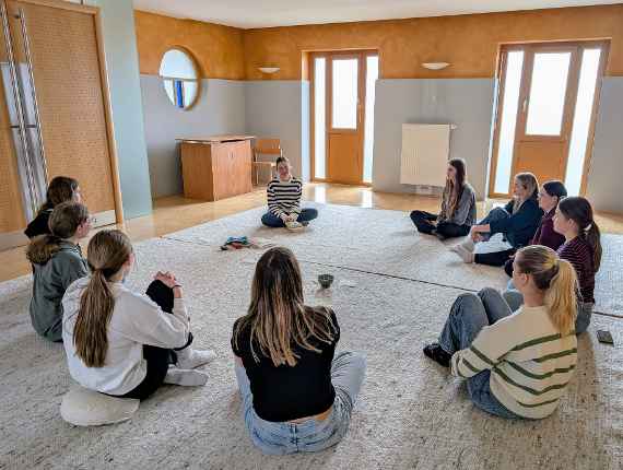 SchülerInnen sitzen im Kreis bei der Präsentation der Lieblingsbücher